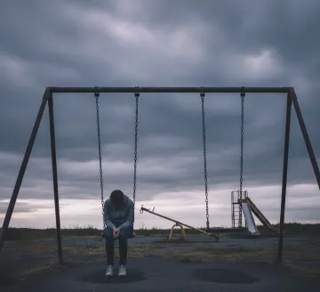 lonely-sad-person-playground-swing-dark-sky